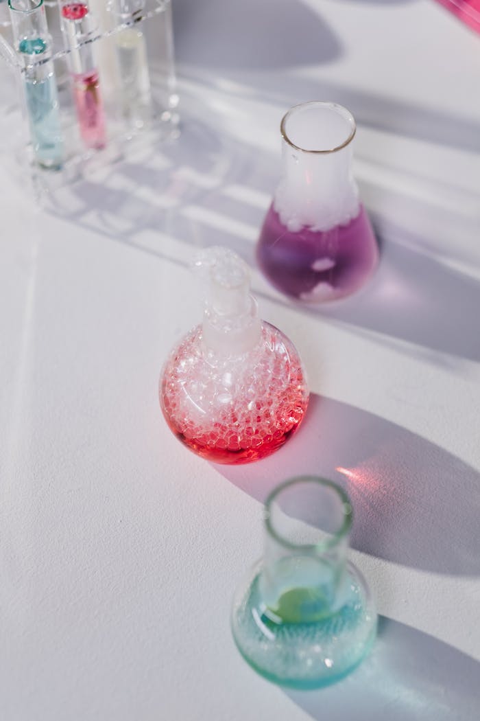 Vibrant glass flasks with colorful liquids in a lab setting.